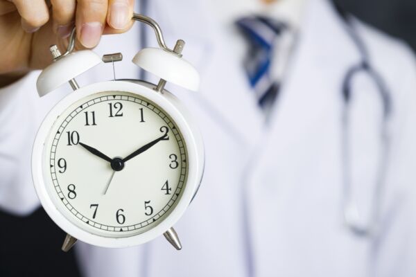 医者が時計を持っている写真