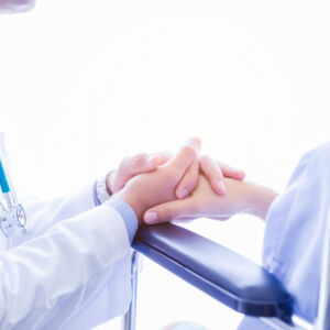 患者と医者が手を取り合う手元写真